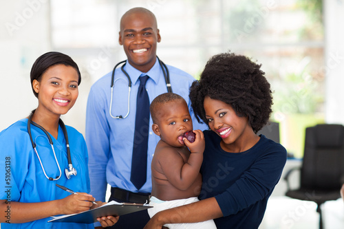 Photo: mother holding her baby after checkup with nurse and doctor mother holding her baby after checkup with nurse and doctor