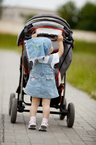 Photo: little funny girl with baby carriage little funny girl with baby carriage