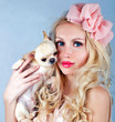Beautiful woman with small dog in hand smiling