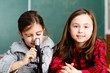 Two schoolgirls have a practice with microscope
