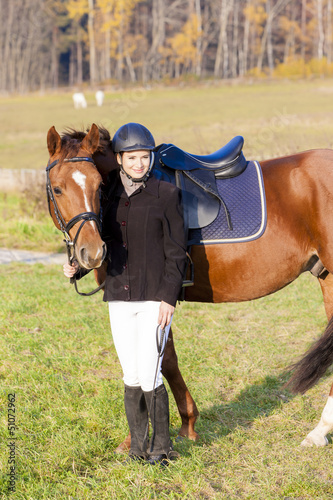 Photo: equestrian with her horse on meadow equestrian with her horse on meadow