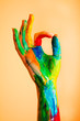 Foto: Painted hand with OK sign, colorful fun. Painted hand with OK sign, colorful fun.