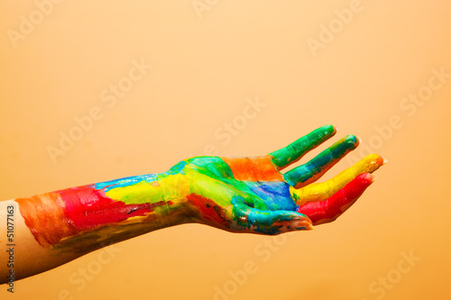 Photo: Painted hand, colorful fun. Orange background Painted hand, colorful fun. Orange background