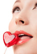 Face portrait of beautiful young woman with heart lollipop