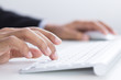 Business hands typing on keyboard in office
