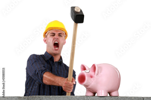 Photo: craftsman breaking a pig bank with a hammer craftsman breaking a pig bank with a hammer
