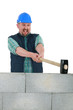 Man destroying wall with sledge-hammer