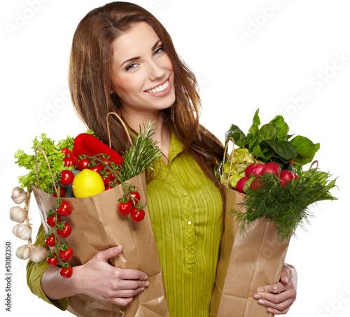 Photo: Portrait of happy young female holding a shopping bag full of gr Portrait of happy young female holding a shopping bag full of gr