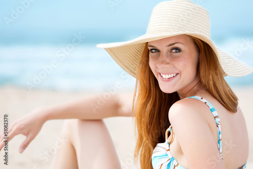 Photo: lächelnde frau mit sonnenhut am strand lächelnde frau mit sonnenhut am strand