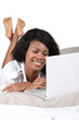 Woman using laptop in bed