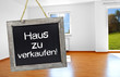 Tafel mit Haus im Hintergrund und zu verkaufen