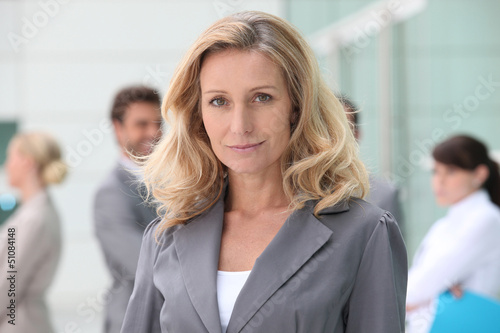 Photo: Woman standing in front of her colleagues Woman standing in front of her colleagues