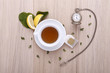 wooden table with cup of tea, watch and lemon