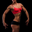 Muscular strong woman on a black background