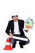businessman holding a blueprint and an energy consumption label