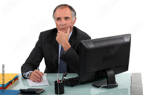 Photo: Pensive senior businessman has to make difficult decision Pensive senior businessman has to make difficult decision