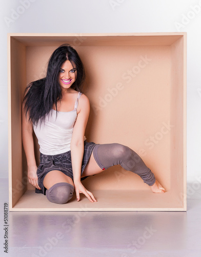 Photo: Happy woman model trapped in box concept Happy woman model trapped in box concept