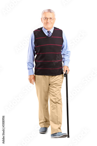 Photo: Full length portrait of a senior man walking with a cane Full length portrait of a senior man walking with a cane
