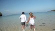 Video: couple holding by hands and running together on coastline couple holding by hands and running together on coastline