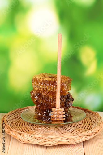 Photo: Honeycomb on wooden table on nature background Honeycomb on wooden table on nature background
