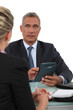 Businessman with calculator talking to his collaborator