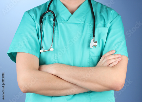 Photo: Doctor with stethoscope, on blue background Doctor with stethoscope, on blue background