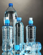 Different water bottles on grey background