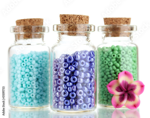 Photo: Little bottles full with colorful beads isolated on white Little bottles full with colorful beads isolated on white