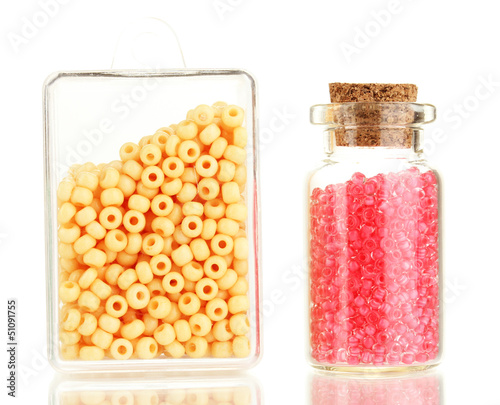 Photo: Colorful beads heap in box and glass bottle isolated on white Colorful beads heap in box and glass bottle isolated on white