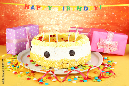 Photo: Happy birthday cake and gifts, on red background Happy birthday cake and gifts, on red background