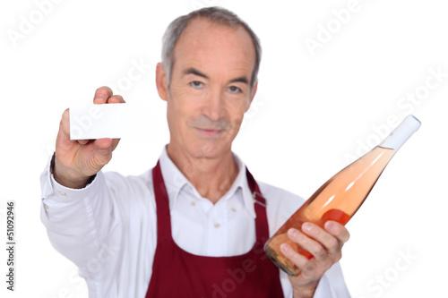 Photo: Senior wine waiter showing businesscard Senior wine waiter showing businesscard
