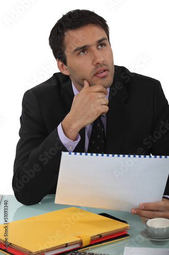 Photo: Businessman thinking about a report Businessman thinking about a report