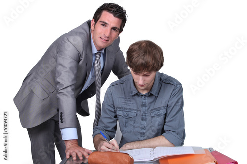 Photo: Teacher helping male teenager Teacher helping male teenager