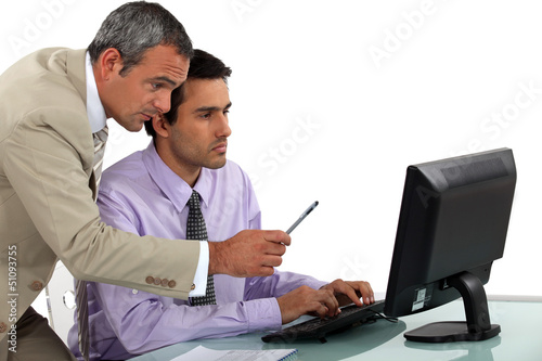 Photo: Man giving pointers to his assistant Man giving pointers to his assistant