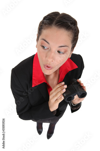 Photo: Curious businesswoman holding binoculars Curious businesswoman holding binoculars