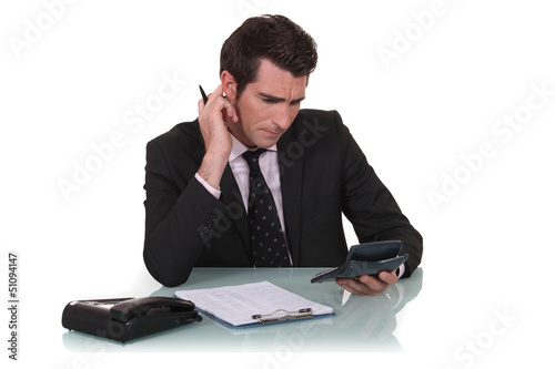 Photo: Office worker using calculator Office worker using calculator