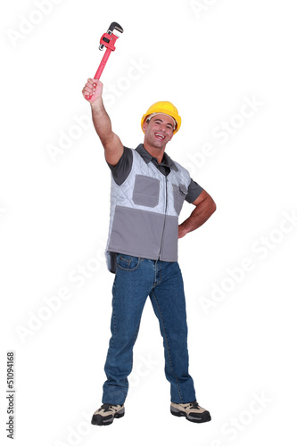 Photo: Man proudly raising wrench in the air Man proudly raising wrench in the air