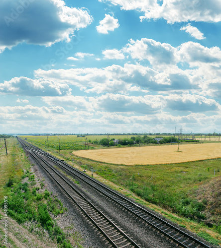 Photo: railroads to horizon and cloudy sky railroads to horizon and cloudy sky