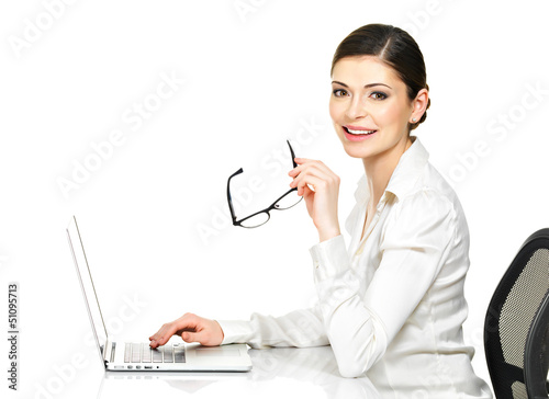 Photo: woman sits from the table and working on laptop woman sits from the table and working on laptop