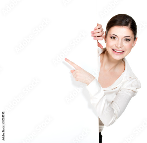 Photo: Happy woman points on the white blank banner Happy woman points on the white blank banner