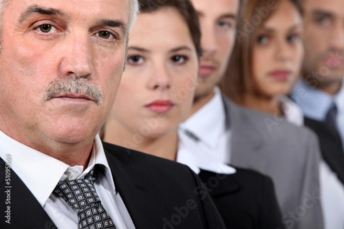 Photo: Head and shoulder shot of five serious co-workers Head and shoulder shot of five serious co-workers