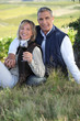 Photo: couple drinking wine in their vineyard couple drinking wine in their vineyard