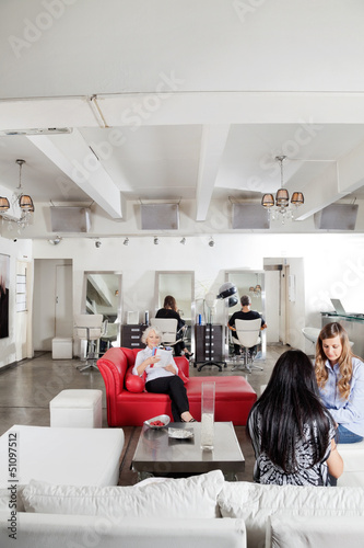 Photo: Client Having Manicure With People Waiting In Salon Client Having Manicure With People Waiting In Salon