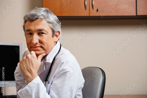 Photo: Serious Doctor With Hand On Chin Serious Doctor With Hand On Chin