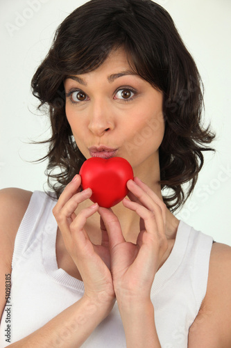 Photo: Attractive woman holding a small red heart Attractive woman holding a small red heart