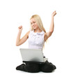 A young woman sitting on the floor with a laptop
