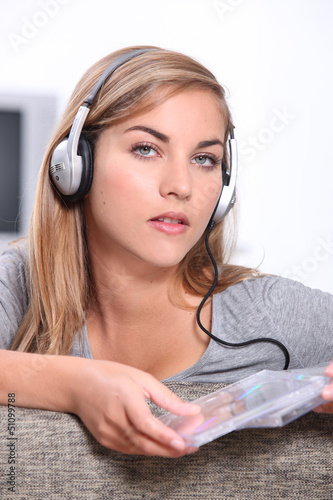 Photo: Young woman listening to CDs Young woman listening to CDs