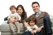 Young parents with kids on couch.