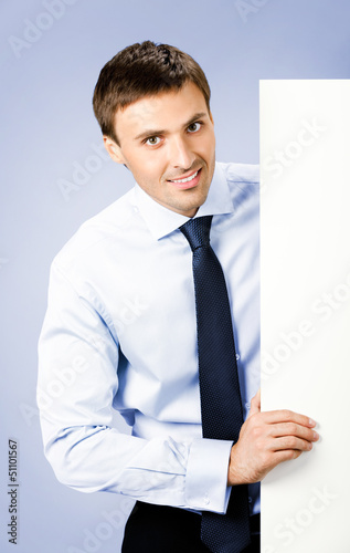 Photo: Business man showing blank signboard, on violet Business man showing blank signboard, on violet