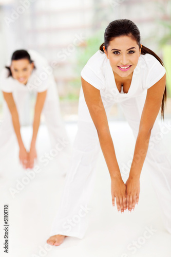 Photo: young woman exercising with friend on background young woman exercising with friend on background